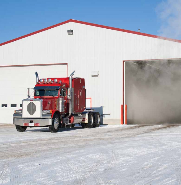 Bright red truck with white garage and steam in background